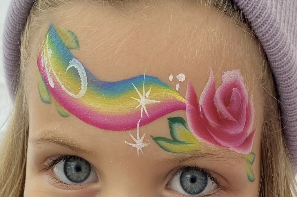 Szivárvány és virág arcfestés kislány homlokán